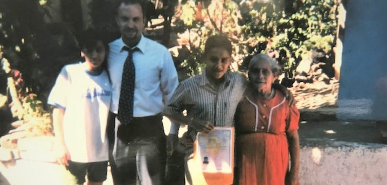 Photo of Robert F. Jacobs with a family of immigrants